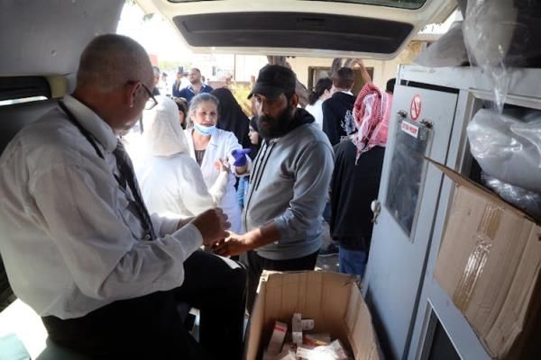 A doctor sits in a mobile medical staion seeing refugees waiting to cross into Syria.