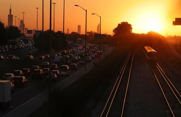 A CTA Blue Line train rolls along as the sun rises over Chicago and the Eisenhower Expressway on Oct. 3, 2023. Weekday service on the system’s two busiest lines, the Red and the Blue, were both cut by about 20%.